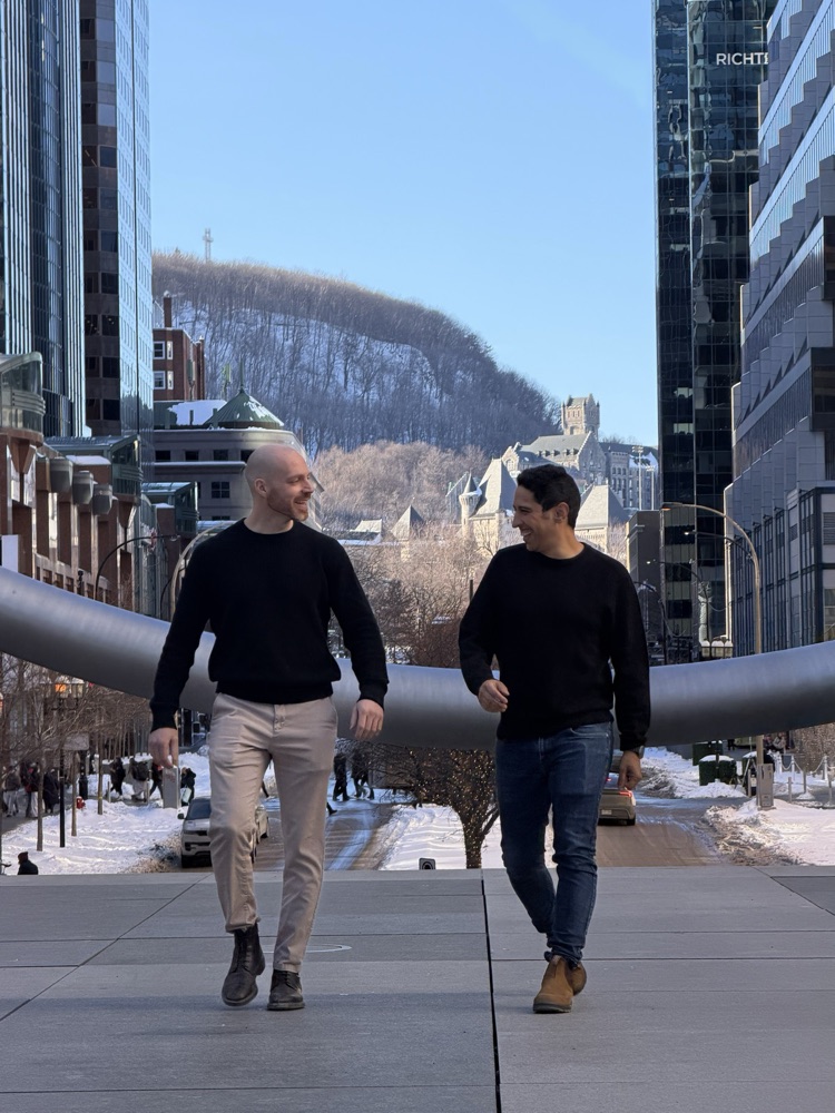 Mehdi Merai et Gabriel De Lisi marchant ensemble dans le centre-ville de Montréal, avec le mont Royal en arrière-plan